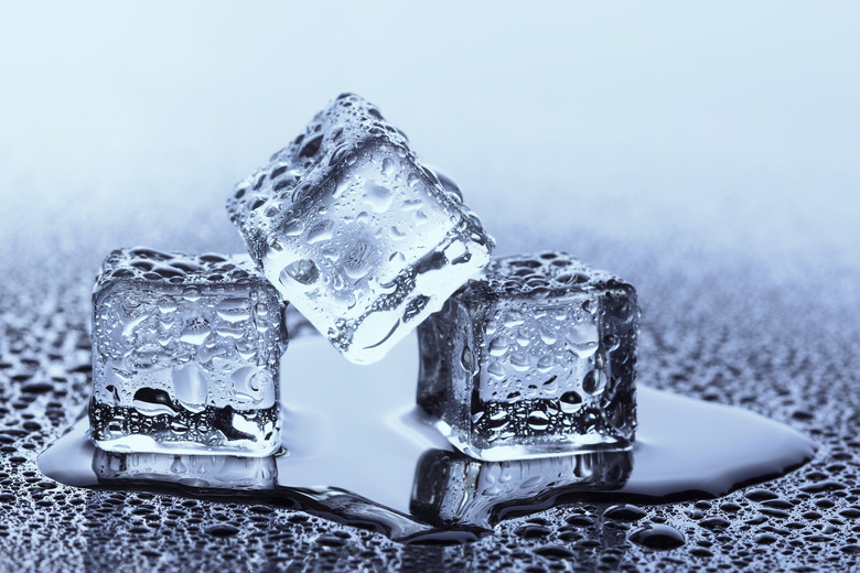 Three real ice cubes covered with cold water droplets